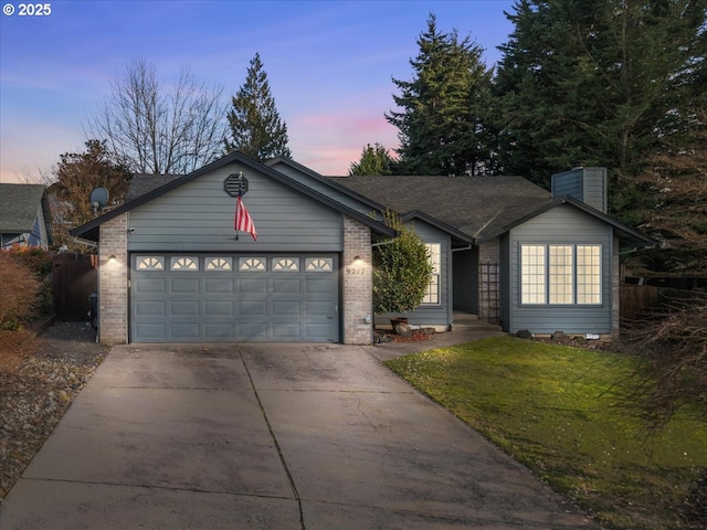 ranch-style house with a yard and a garage