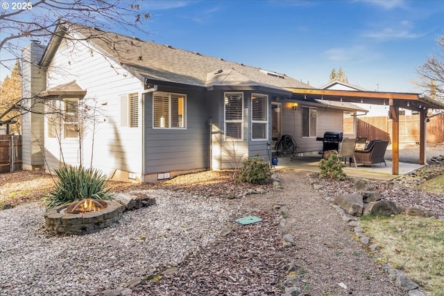 rear view of property featuring a patio and an outdoor fire pit