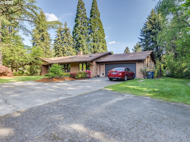 single story home with aphalt driveway, a chimney, a front yard, and a garage