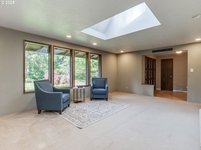 living area with recessed lighting, a skylight, and carpet