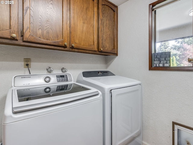 laundry area featuring separate washer and dryer and cabinet space
