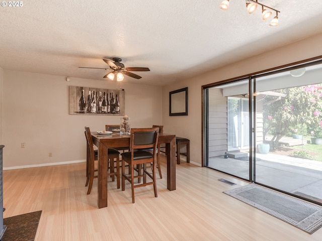 dining space with visible vents, a textured ceiling, light wood finished floors, and ceiling fan