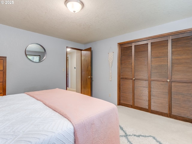 bedroom featuring carpet, a closet, and a textured ceiling
