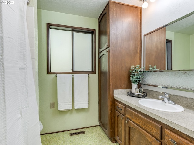 full bath with visible vents, a textured ceiling, a shower with curtain, and vanity