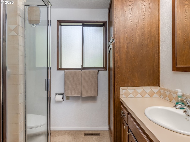 full bathroom with visible vents, baseboards, an enclosed shower, and vanity