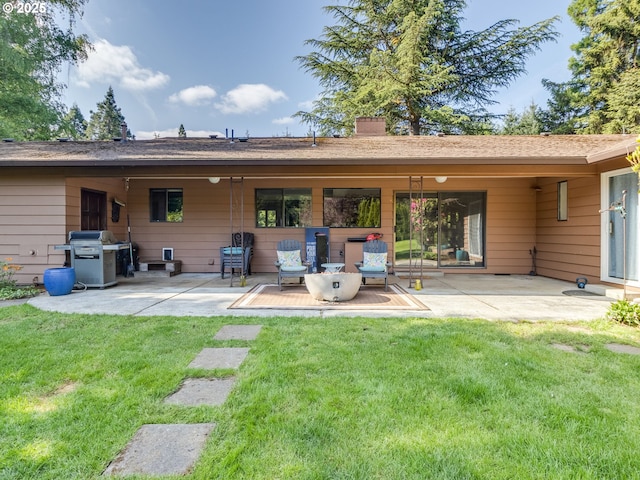 rear view of house with a lawn, a patio, and a chimney