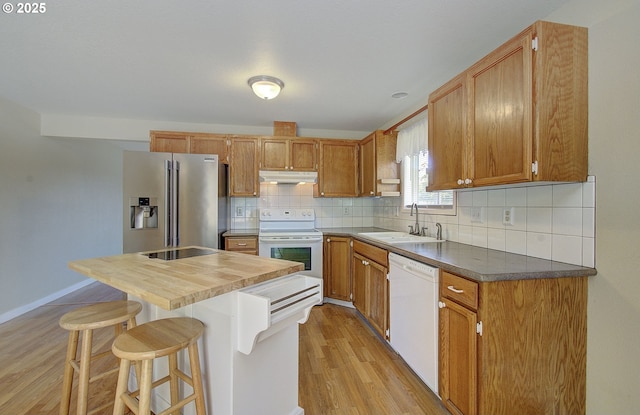 10808 NE 92nd Cir, Vancouver, WA 98662 - kitchen with white appliances, under cabinet range hood, light wood-type flooring, a breakfast bar area, and wood counters