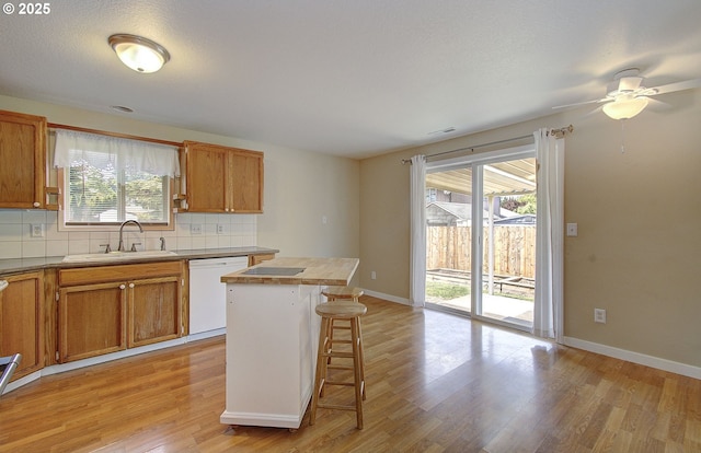 10808 NE 92nd Cir, Vancouver, WA 98662 - kitchen with white dishwasher, light wood-type flooring, a breakfast bar, decorative backsplash, and ceiling fan
