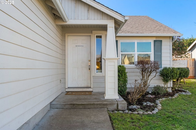 doorway to property featuring roof with shingles