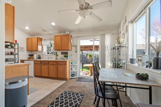 kitchen featuring light tile patterned floors, a ceiling fan, lofted ceiling, white dishwasher, and light countertops