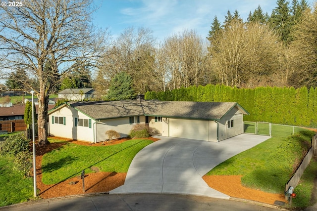 ranch-style home with a front yard, an attached garage, fence, and concrete driveway
