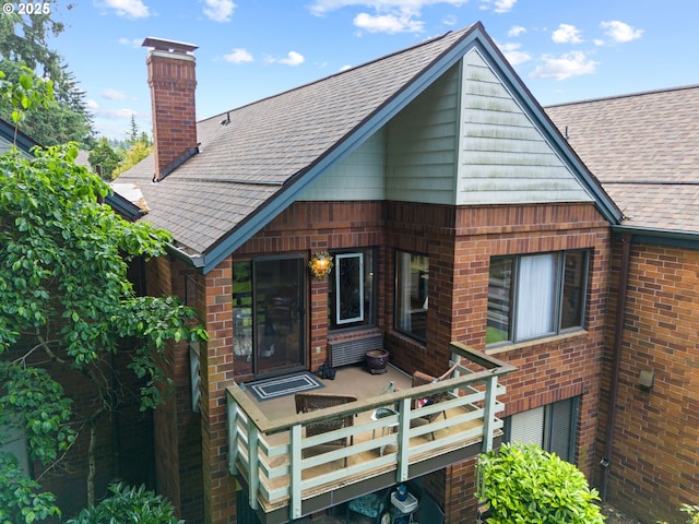 14935 NE Sacramento St Unit 28, Portland, OR 97230 - back of property featuring roof with shingles, a chimney, and brick siding