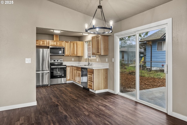 kitchen featuring hanging light fixtures, appliances with stainless steel finishes, sink, and dark hardwood / wood-style floors