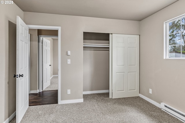 unfurnished bedroom with carpet floors, a baseboard radiator, and a closet