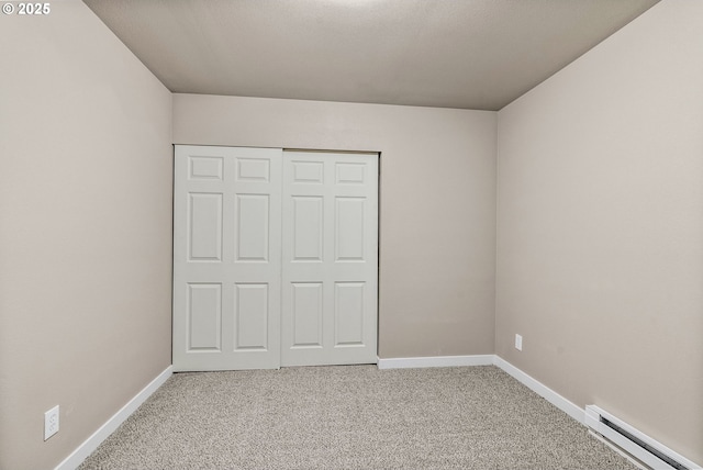 unfurnished bedroom with a baseboard radiator, light colored carpet, and a closet