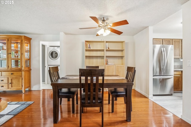 5160 SW 180th Ave Unit 17, Beaverton, OR 97078 - dining area with stacked washer / dryer, a textured ceiling, light wood-style floors, a ceiling fan, and baseboards