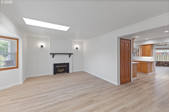 921 SE 168th Ave, Portland, OR 97233 - unfurnished living room with a skylight, healthy amount of natural light, light wood-style floors, a textured ceiling, and crown molding