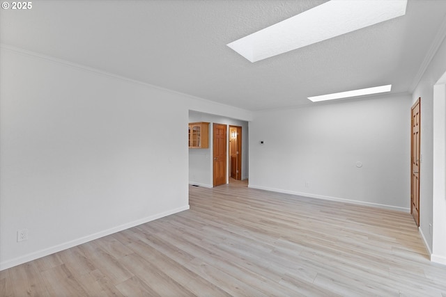921 SE 168th Ave, Portland, OR 97233 - empty room with a skylight, ornamental molding, light wood-style flooring, and a textured ceiling