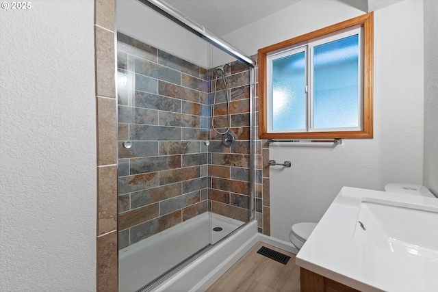 921 SE 168th Ave, Portland, OR 97233 - full bathroom with a tile shower, vanity, a textured wall, and wood finished floors