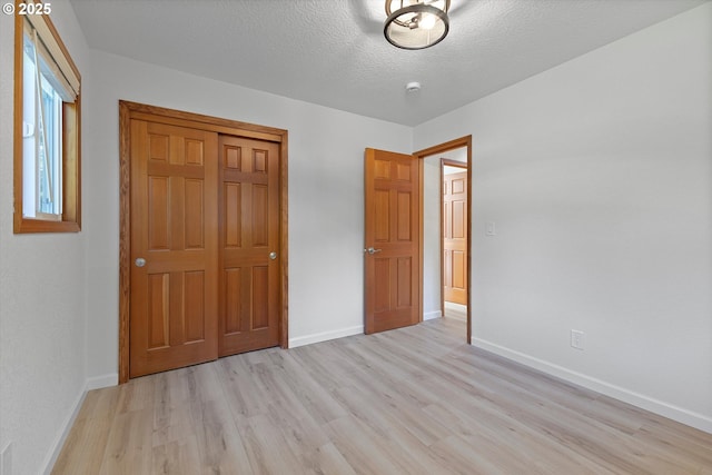 921 SE 168th Ave, Portland, OR 97233 - unfurnished bedroom featuring light wood finished floors and a textured ceiling