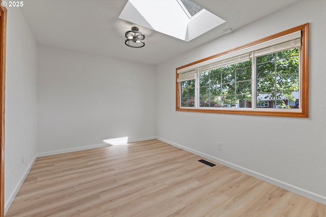 921 SE 168th Ave, Portland, OR 97233 - spare room with a skylight, wood finished floors, and healthy amount of natural light