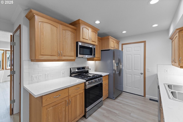 921 SE 168th Ave, Portland, OR 97233 - kitchen with appliances with stainless steel finishes, recessed lighting, light wood-type flooring, decorative backsplash, and light countertops