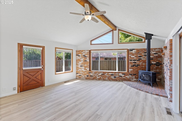 921 SE 168th Ave, Portland, OR 97233 - unfurnished living room with a wood stove, wood finished floors, a ceiling fan, and a textured ceiling