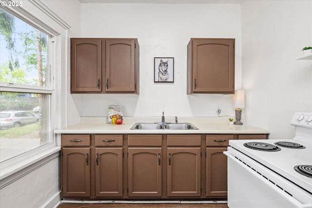 561 Madison St, Eugene, OR 97402 - kitchen featuring white range with electric stovetop, light countertops, and a sink