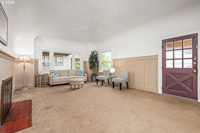 561 Madison St, Eugene, OR 97402 - carpeted living room with a decorative wall, a wainscoted wall, and a glass covered fireplace