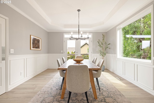 10695 SW Meier Dr, Tualatin, OR 97062 - dining room featuring a chandelier, a raised ceiling, light wood-style floors, a decorative wall, and ornamental molding