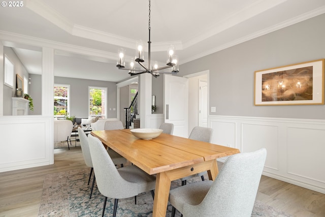 10695 SW Meier Dr, Tualatin, OR 97062 - dining area featuring light wood-style floors, a chandelier, stairs, crown molding, and wainscoting
