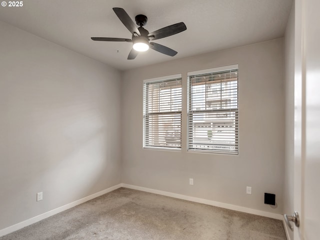 empty room with ceiling fan, carpet, and baseboards