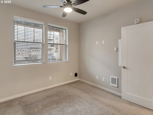 carpeted empty room featuring ceiling fan, visible vents, and baseboards