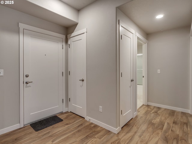 foyer with light wood-style flooring, baseboards, and recessed lighting