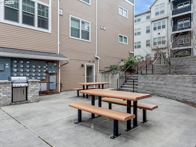 view of patio featuring stairs, grilling area, exterior kitchen, and outdoor dining space