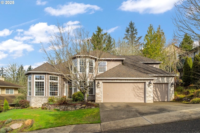 traditional-style house featuring a garage, a front yard, driveway, and a shingled roof