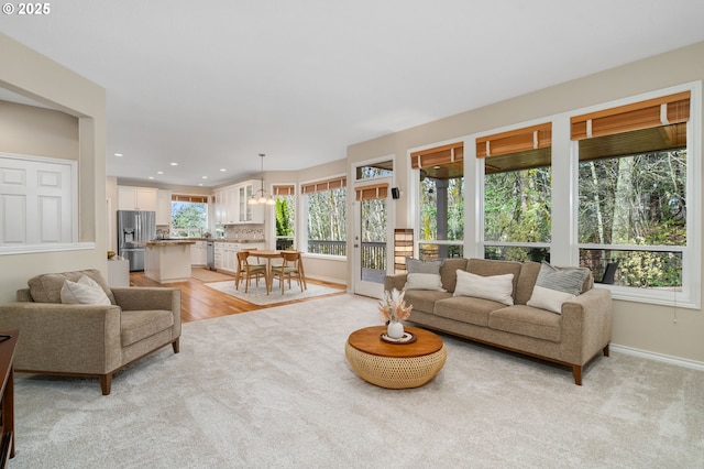 living room with light carpet, recessed lighting, light wood-style flooring, and baseboards