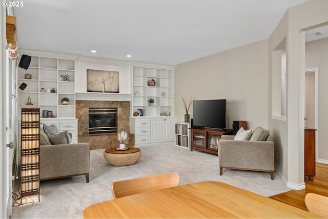 living room featuring light carpet, recessed lighting, baseboards, and a premium fireplace