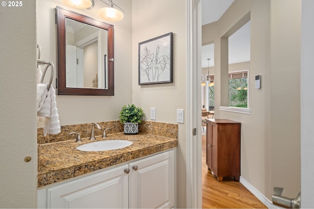 bathroom featuring vanity, wood finished floors, and baseboards