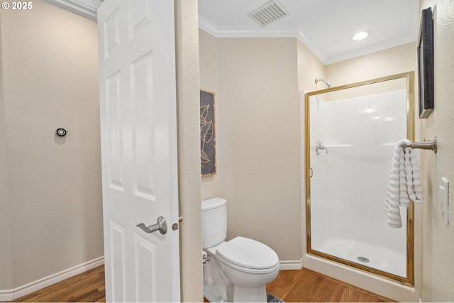 full bath featuring visible vents, a shower stall, toilet, ornamental molding, and wood finished floors