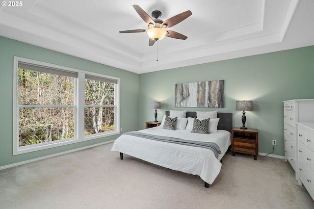 bedroom with baseboards, a raised ceiling, ceiling fan, and carpet flooring