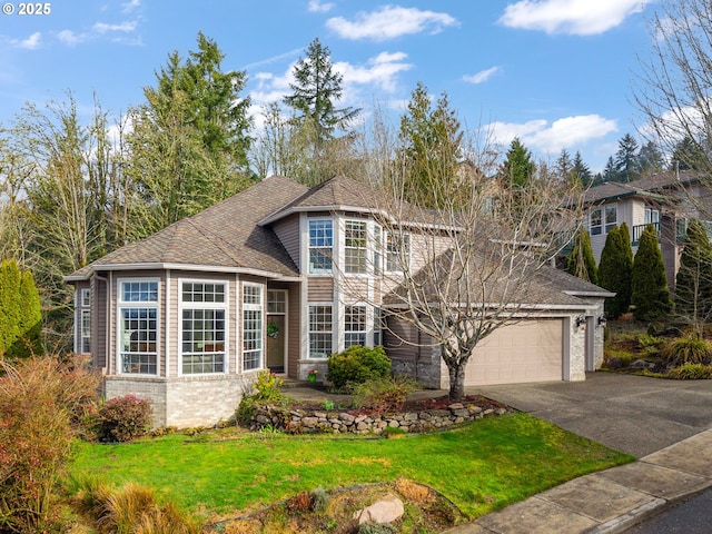 traditional-style house featuring a shingled roof, aphalt driveway, a garage, and a front lawn