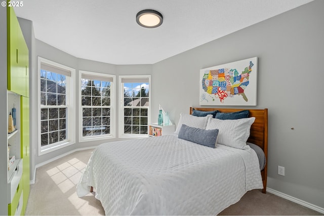 bedroom featuring light colored carpet and baseboards