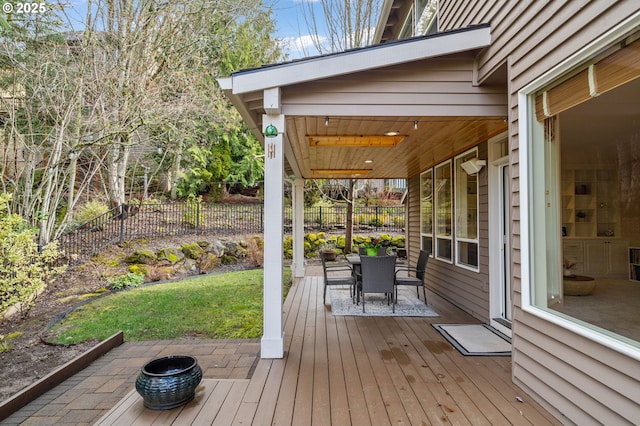 deck featuring outdoor dining area and fence