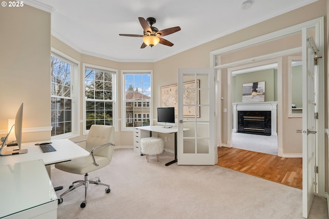 office space featuring a high end fireplace, carpet, ceiling fan, and crown molding