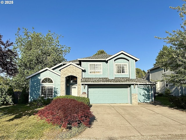 2942 NW Watkins Ct, Camas, WA 98607 - view of front of house with an attached garage, driveway, brick siding, and roof with shingles
