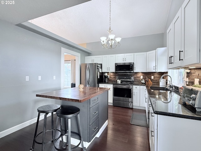 2942 NW Watkins Ct, Camas, WA 98607 - kitchen with appliances with stainless steel finishes, white cabinetry, backsplash, a chandelier, and a textured ceiling