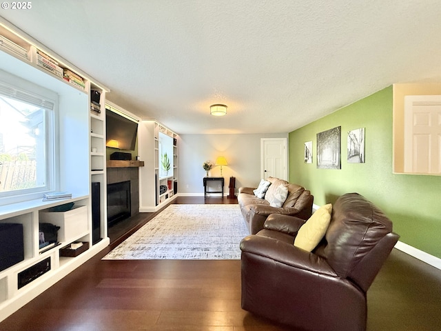2942 NW Watkins Ct, Camas, WA 98607 - living room featuring a glass covered fireplace, dark wood-type flooring, and a textured ceiling