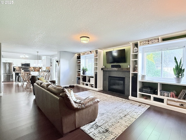 2942 NW Watkins Ct, Camas, WA 98607 - living area featuring a tile fireplace, dark wood finished floors, a textured ceiling, and built in features
