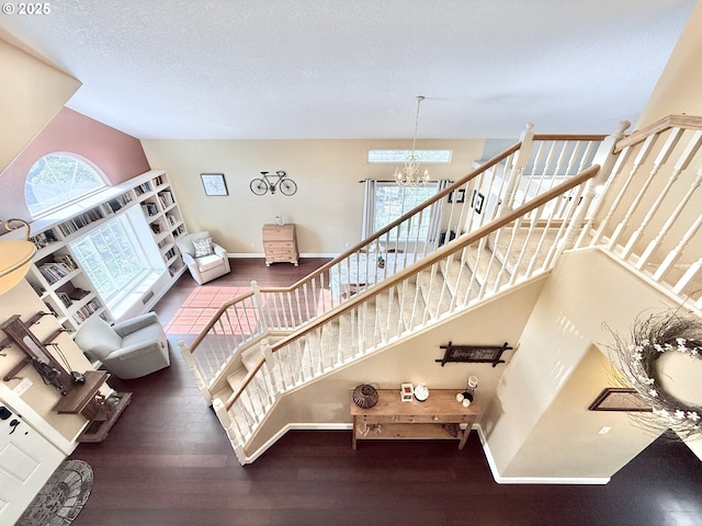 2942 NW Watkins Ct, Camas, WA 98607 - staircase featuring a chandelier, wood finished floors, and vaulted ceiling